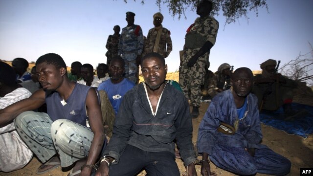 Soldiers guard handcuffed prisoners on March 1 after French and Malian troops reportedly launched an operation the previous day in the village of Kadji, northern Mali, where Islamists are hiding out on an island on the Niger River.