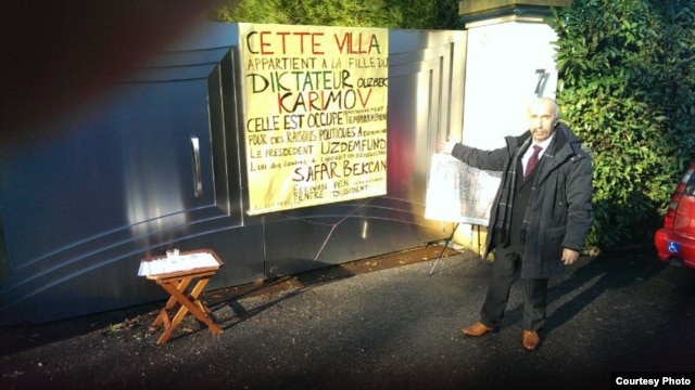 Uzbek dissident Safar Bekjon stands next to the sign identifying Gulnora Karimova's house in Geneva on December 23.