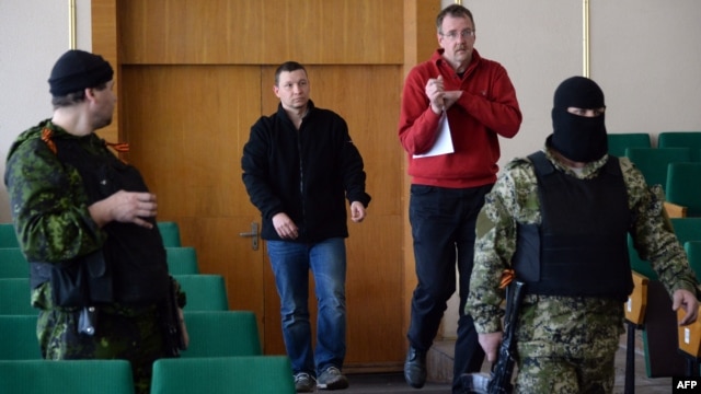 Two of the eight captive members of an OSCE military verification team are marched in under armed guard for a press conference organized by pro-Russian separatists in Slovyansk on April 27.