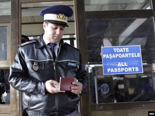 A Romanian customs officer checks a passport at the border with Moldova in Albita.
