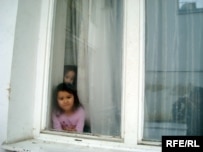 Children of Kazakh asylum seekers peek out of their dormitory in Brno, Czech Republic