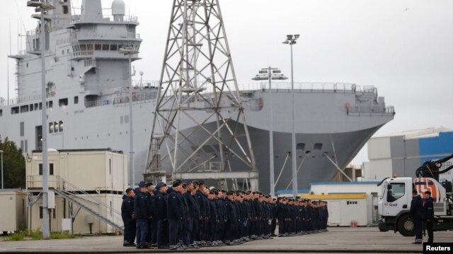 Russian sailors gather in front of the Mistral-class helicopter carrier 'Vladivostok' at the STX Les Chantiers de l'Atlantique shipyard site in Saint-Nazaire on December 17.