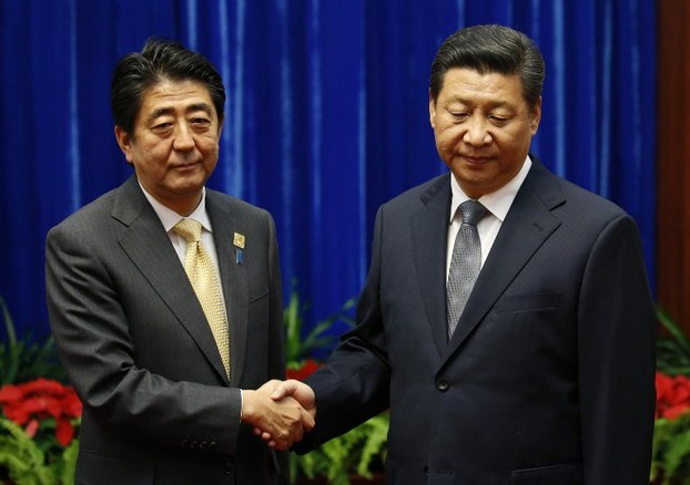 China's President Xi Jinping (R) shakes hands with Japan's Prime Minister Shinzo Abe (L) at the Great Hall of the People on the sidelines of the APEC Summit in Beijing, Nov. 10, 2014.