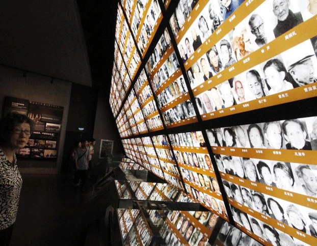 Visitors looking at photos of victims at the Nanjing Massacre Memorial Hall in Nanjing, in eastern China's Jiangsu province, June 11, 2014.