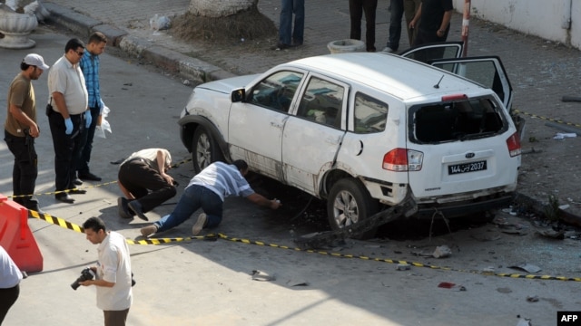 Tunisian police inspect a vehicle that was booby-trapped on July 27 on the outskirts of the Tunisian capital, Tunis. 