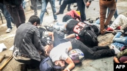 Injured protesters lie on the ground as Turkish riot police fire tear gas to disperse demonstrators gathered near Taksim Square in Istanbul in May 2014.