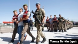 Soldiers accused of participating in the 2016 attempted coup in Turkey are brought to court inside the Sincan prison before trial in Ankara in August 2017.