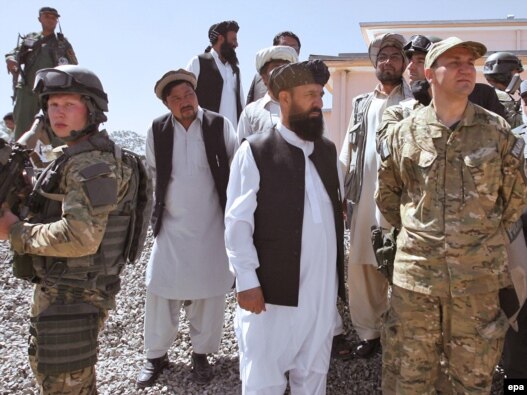 Polish Foreign Minister Radoslaw Sikorski (right) stands with governor of Ghazni Province Musa Khan Akbarzada (center) as he visited reconstruction work and Polish soldiers in Afghanistan in June 2010.
