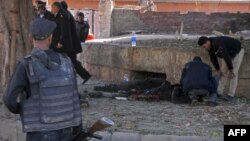 Egyptian security forces check a body at the site of a bomb attack next to a police checkpoint in the western Talibiya district of the capital, Cairo, on December 9.