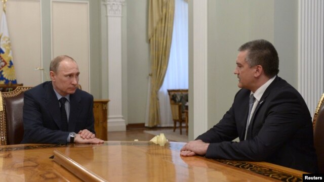 Russian President Vladimir Putin (left) meets with Crimean leader Sergei Aksyonov at the Novo-Ogaryovo state residence outside Moscow on April 14, where he named him acting governor.