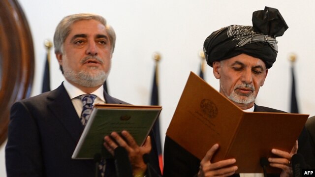 Afghan President Ashraf Ghani (right) administers the oath to Abdullah Abdullah as Afghanistan's newly created post of chief executive in Kabul on September 29.