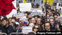 Protesters hold posters depicting political prisoners during an opposition rally in Moscow on June 10.