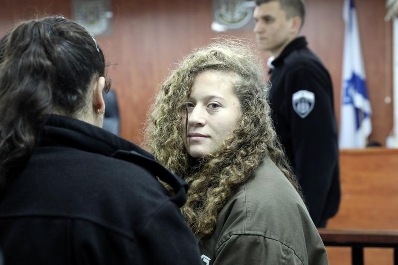 Palestinian teen Ahed Tamimi enters a military courtroom escorted by Israeli Prison Service personnel at Ofer Prison, near the West Bank city of Ramallah, January 1, 2018.