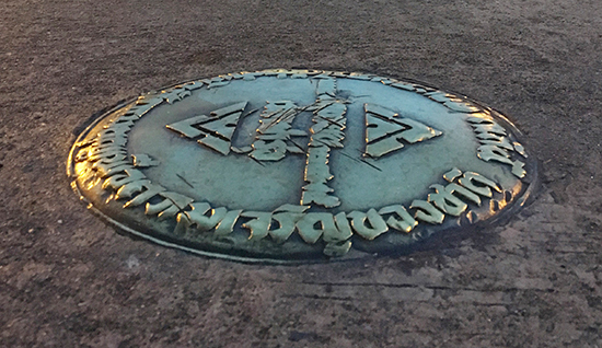 In this October 2, 2016, file photo, a small bronze plaque commemorating Thailand's 1932 revolution rests in the pavement of the Royal Plaza in Bangkok, Thailand. In early April, the plaque was mysteriously removed by parties unknown and substituted with one praising the Chakri Dynasty, whose 10th king took the throne in December 2016. The Foreign Correspondents' Club of Thailand accepted a police request that it cancel a panel discussion on the removal of the plaque commemorating the end the country's absolute monarchy in 1932. (AP Photo/Apichart Khunnawatbandit)