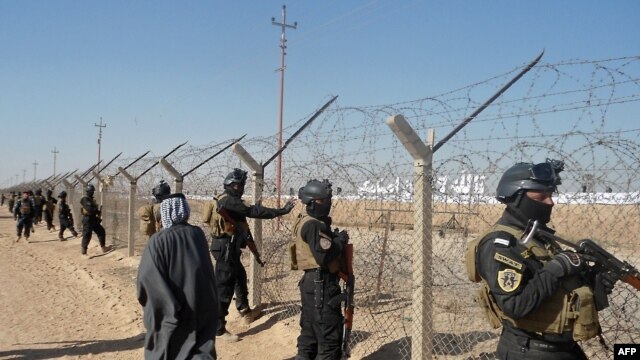 Iraqi SWAT forces stand guard outside Camp Ashraf during a protest on December 9 by Iraqis calling for the camp to be closed and for its residents to be deported.