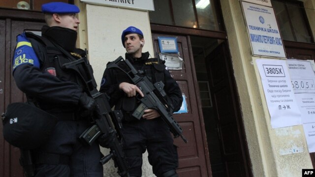 EULEX policemen secure the entrance of a polling station in the Serb-populated part of the ethnically divided town of Kosovska Mitrovica during elections in November 2013.