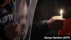 People hold a picture of Kateryna Handzyuk in front of the Interior Ministry in Kyiv in remembrance of the anticorruption campaigner on November 4.