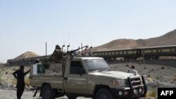 Pakistani soldiers stand near a train at the site of two explosions in the town of Mach, 55 kilometers east of Balochistan's provincial capital Quetta.