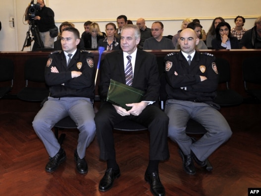 Former Croatian Prime Minister Ivo Sanader is flanked by court policemen at the beginning of his trial in Zagreb on November 3.