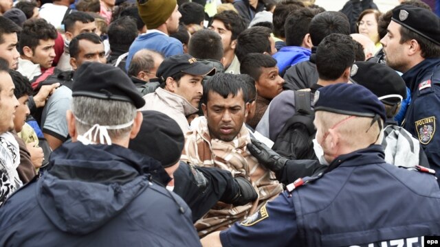 Austrian police directs refugees waiting for busses at a reception camp at the Austrian-Hungarian border in Nickelsdorf, Austria. (file photo)