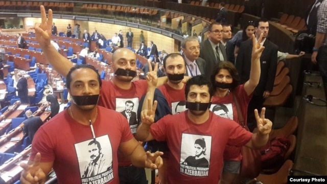 Azerbaijani activists protests against Azerbaijani President Ilham Aliyev's speech at the Council of Europe's Parliamentary Assembly in Strasbourg on June 24.