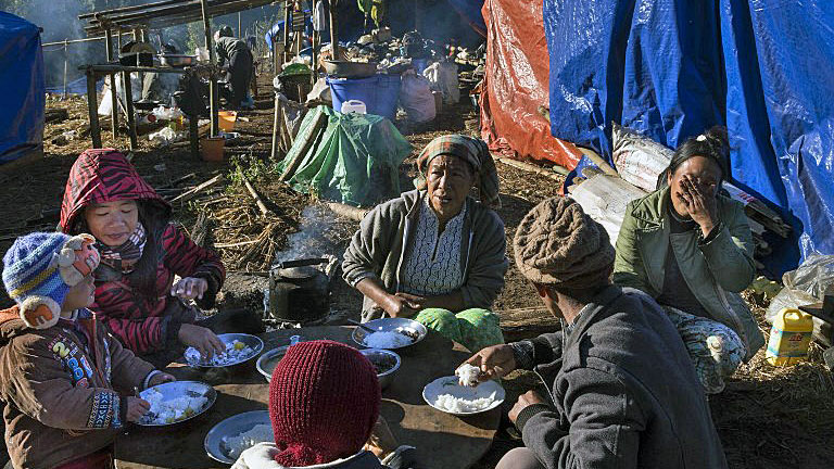 An ethnic Kachin refugee family eats near Lung Byeng village, Waimaw township, in northern Myanmar's Kachin state, Jan. 21, 2017.