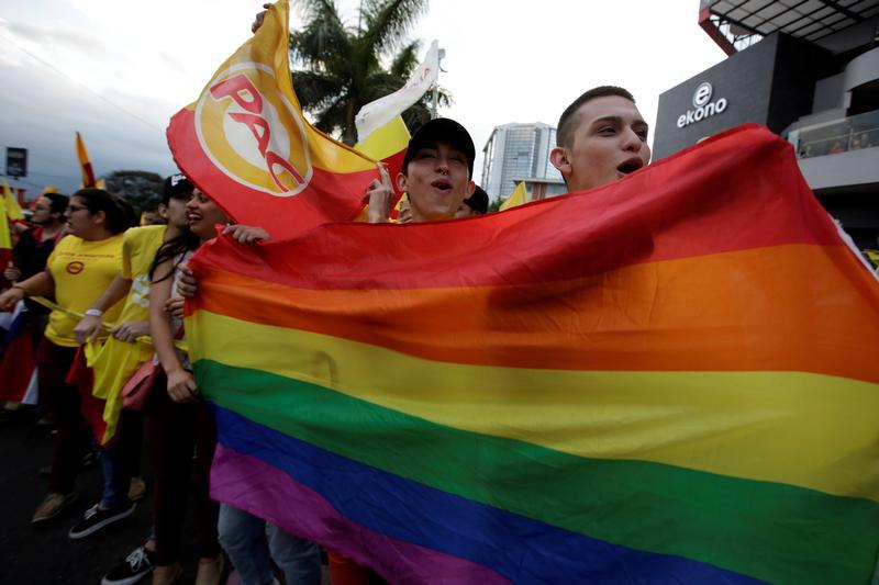 Supporters of Carlos Alvarado Quesada, presidential candidate of the ruling Citizens' Action Party (PAC), hold up a rainbow LGBT pride flag during the presidential election in San Jose, Costa Rica, April 1, 2018.