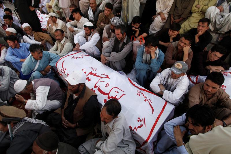 Shi'ite Muslim men from Pakistan's ethnic Hazara minority mourn around the coffins of their relatives, who were killed in a shooting attack, in Quetta, Pakistan October 9, 2017.