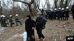 Migrants pass security forces on their way to Macedonia and the Balkans route to the European Union