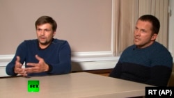 Men identifying themselves as Ruslan Boshirov (left) and Aleksandr Petrov – now believed to be GRU officers Anatoly Chepiga (left) and Aleksandr Mishkin – speak to the Kremlin-funded RT channel in Moscow on September 13.