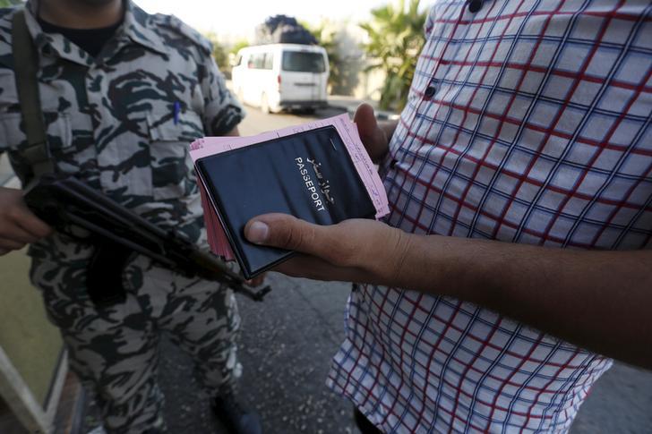 A General Security officer stands by as a Syrian bus driver carries the passports and departure cards of Syrians arriving in Lebanon.