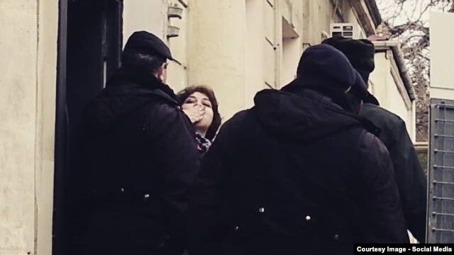 Khadija Ismayil tries to greet supporters and journalists outside the Baku courtroom on Januarya 27, when she had her pretrial detention extended. (POOR QUALITY PHOTO)