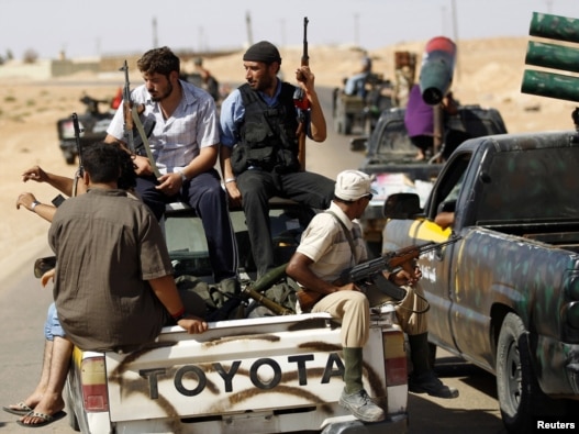 Rebel fighters patrol the town of Abu Grein, some 128 kilometers west of Sirte, on August 29.