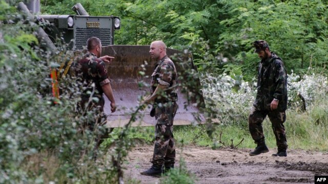 Soldiers of the Hungarian Army's technical unit prepare the first section of a metal fence at the Hungarian-Serbian border near the village of Morahalom on July 13.