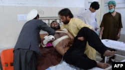 Relatives move a victim onto a bed as he receives treatment at a hospital following multiple explosions that targeted a cricket stadium in Jalalabad on May 19. Eight people were killed.