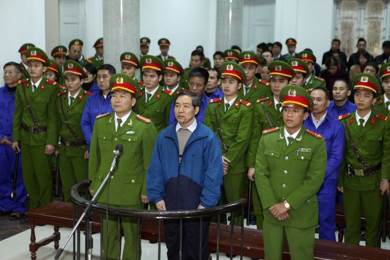 Duong Chi Dung (C-front) and his accomplices listen to the verdict at the Hanoi People's Court, Dec. 16, 2013.