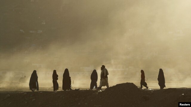 Women clad in burqas walk along a street as the sun sets in Kabul. (file photo)