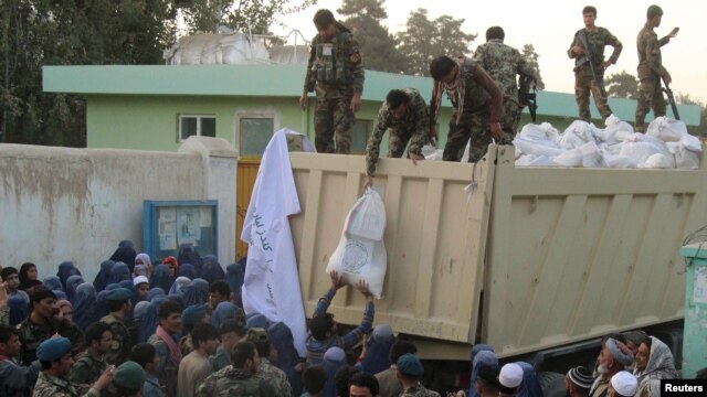 Afghan National Army troops distribute aid to the civilians of Kunduz on October 14.