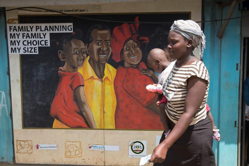 A woman walks past a mural on a Family Health Options clinic in the Kibera slums in Nairobi, Kenya, May 16, 2017.