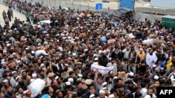 People wait to cross the border into Afghanistan from Pakistan at the Torkham border post in Pakistan's Khyber Agency on March 7.