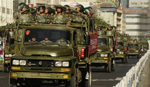 Chinese paramilitary police trucks drive through downtown Urumqi, July 9, 2009. AFP