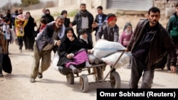 People flee the rebel-held town of Hammuriyeh on March 15.