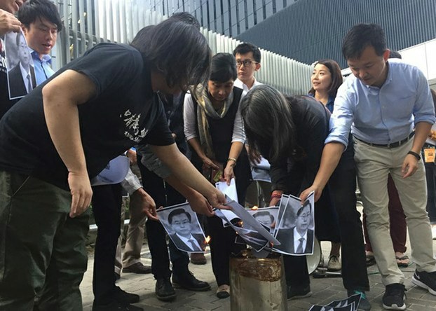 Hong Kong opposition groups burn photos of Zhang Dejiang, chairman of China's National People's Congress, over the announcement the rubber stamp NPC will intervene in a local dispute over two pro-independence lawmakers, Nov. 4, 2016.