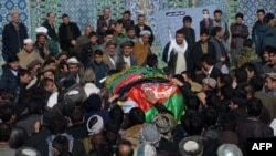 Afghan mourners carry the coffin of one of the six Afghan employees of the Red Cross in Mazar-e Sharif on February 9.