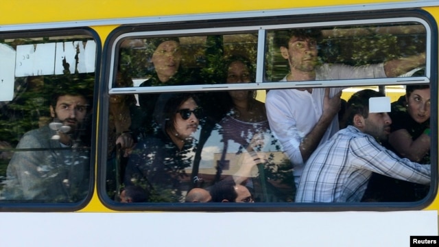 Gay-rights activists look out from a bus as they are evacuated by police during clashes in Tbilisi on May 17.
