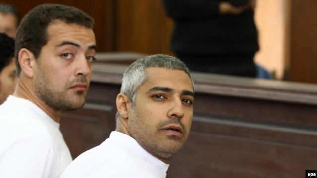 Al-Jazeera journalists Mohammed Fahmy and Baher Mahmoud (left) on trial in Cairo in March