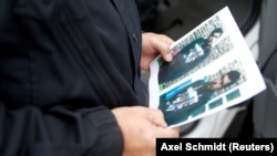 A German policeman holds a picture of Jaber Al-Bakr.