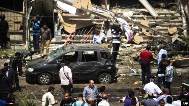 People gather at the site of a bomb that targeted the convoy of Egyptian Interior Minister Muhammad Ibrahim in Cairo.