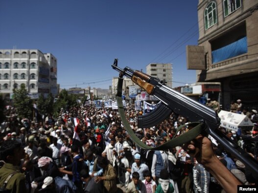 A defected army soldier now backing Yemen's antigovernment protesters waves his AK-47 rifle during a protest march in Sanaa on October 20.