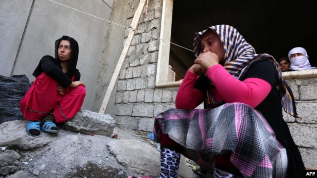 Iraqi Yazidi women who fled the violence in the northern Iraqi town of Sinjar sit outside a school where they are taking shelter in the Kurdish city of Dohuk in Iraq's autonomous Kurdistan region.